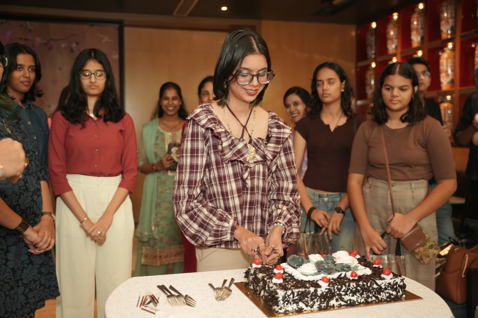 Cutting the cake with friends by her side.