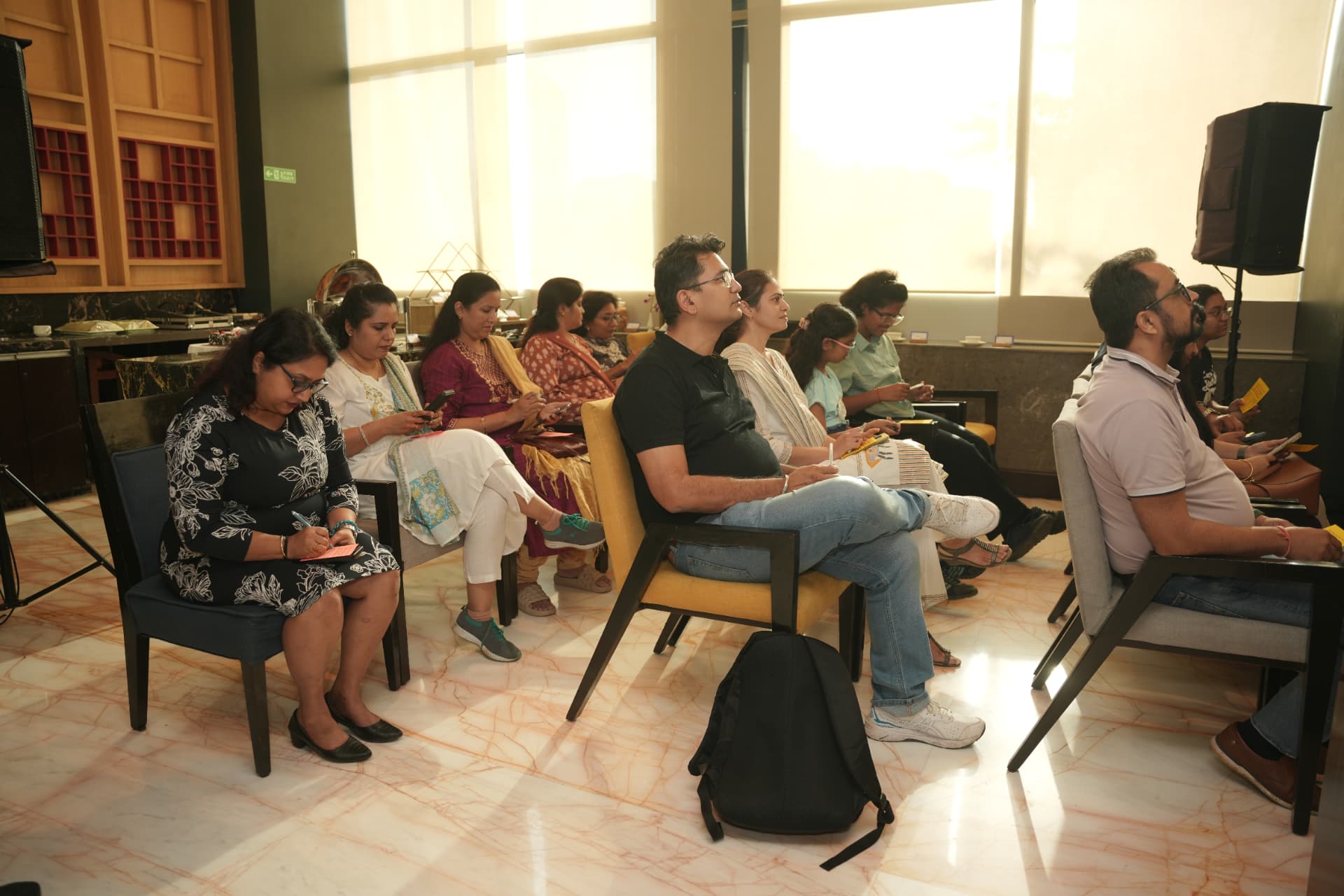 Attendees listen, penning their own notes.